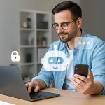 Man using a laptop and smartphone with chatbot icons, representing nonprofit donor engagement through AI and web design.